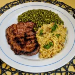 Schweinenackensteak mit Erbsen an Kartoffelstampf Rezept