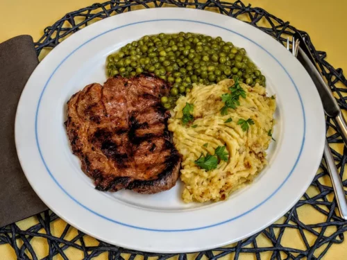 Schweinenackensteak mit Erbsen an Kartoffelstampf Rezept